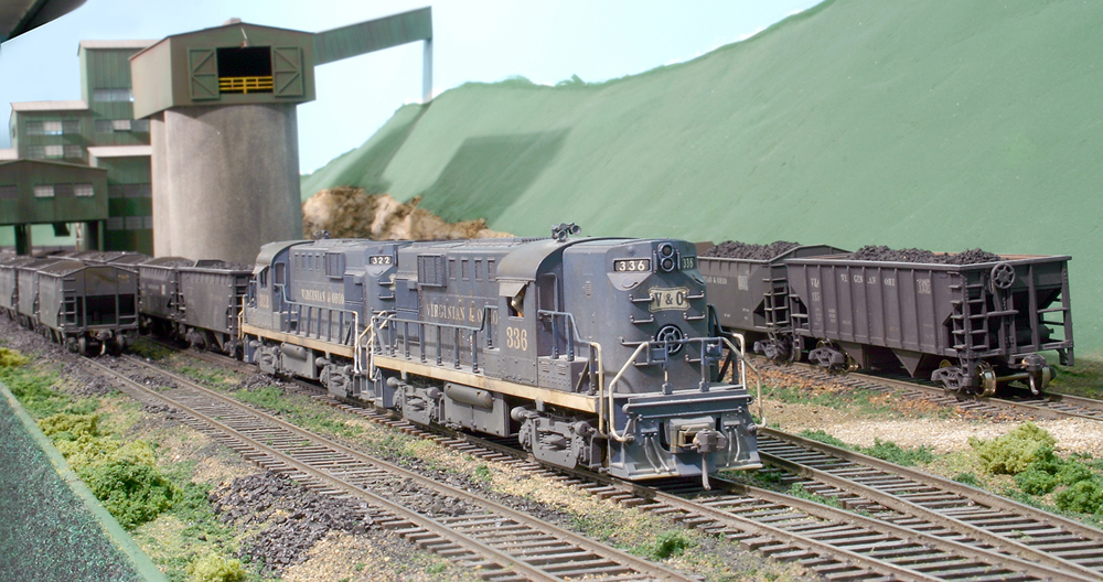 Two diesel locomotives working hopper cars at a coal tipple