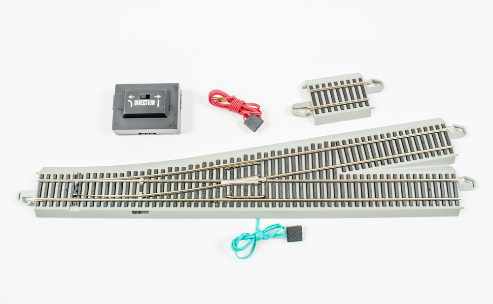 Photo of HO scale turnout with filler piece, controller, and wires