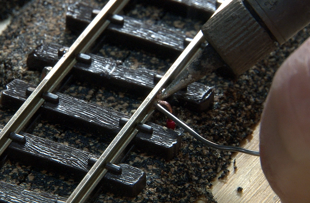 A soldering iron being used on the tip of the wire.