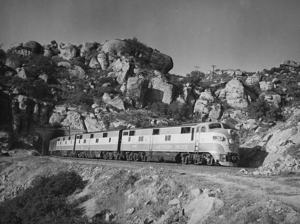 black and white train coming out of tunnel