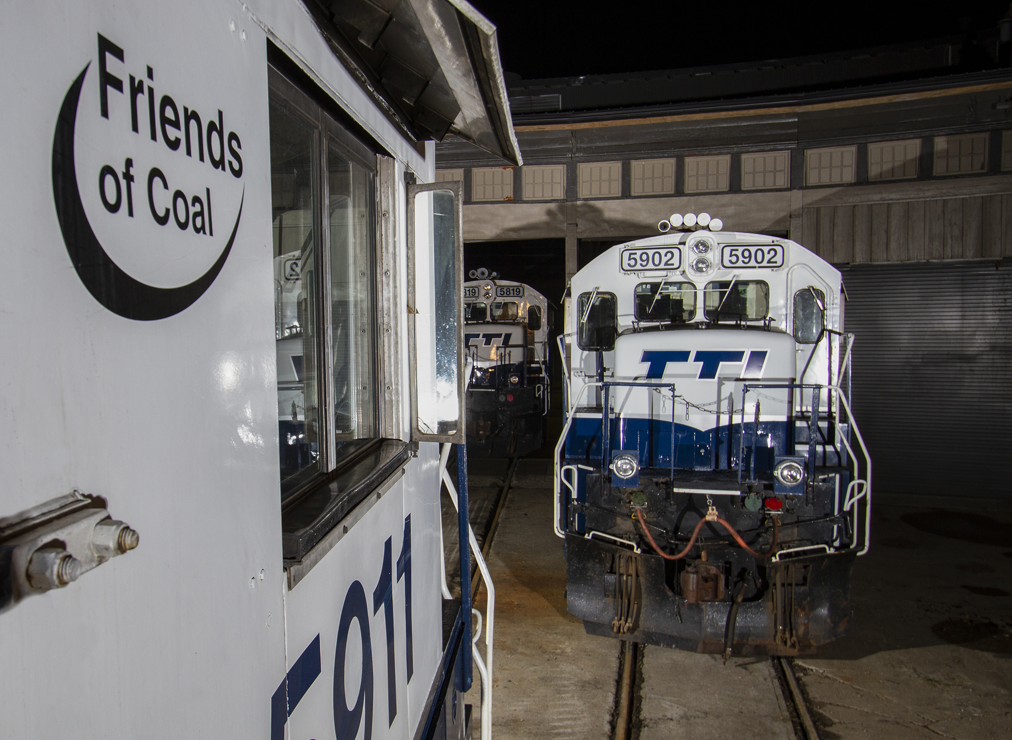 three white and blue locomotives parked