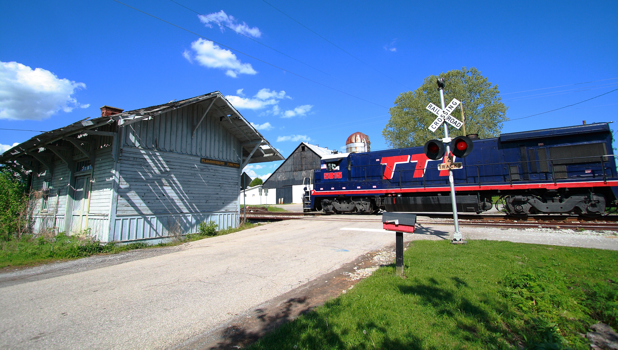 blue and red locomotive by station