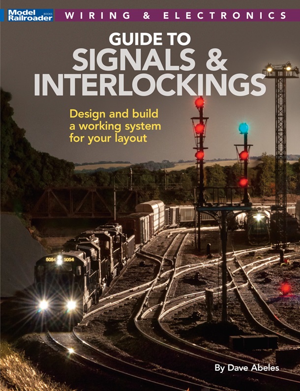 Model railroad scene with colorful, lit signals.