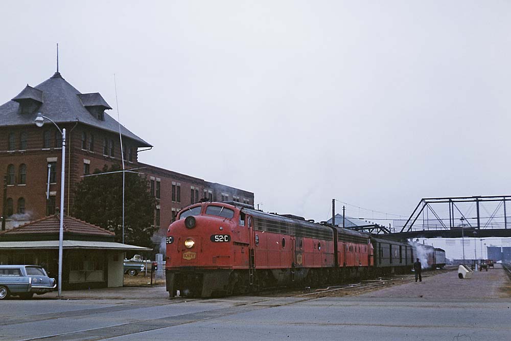Red diesel Missouri-Kansas-Texas locomotive at passenger station