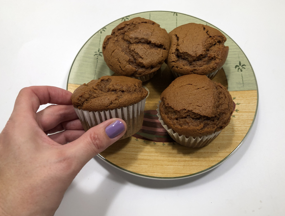 four muffins with a hand holding one
