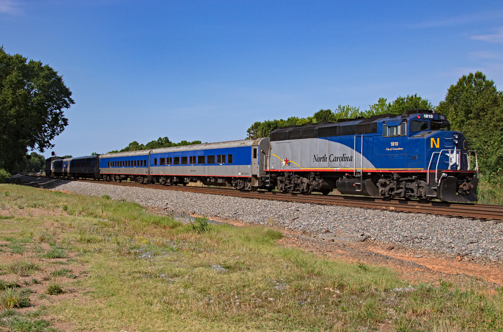blue and gray passenger train in a country scene