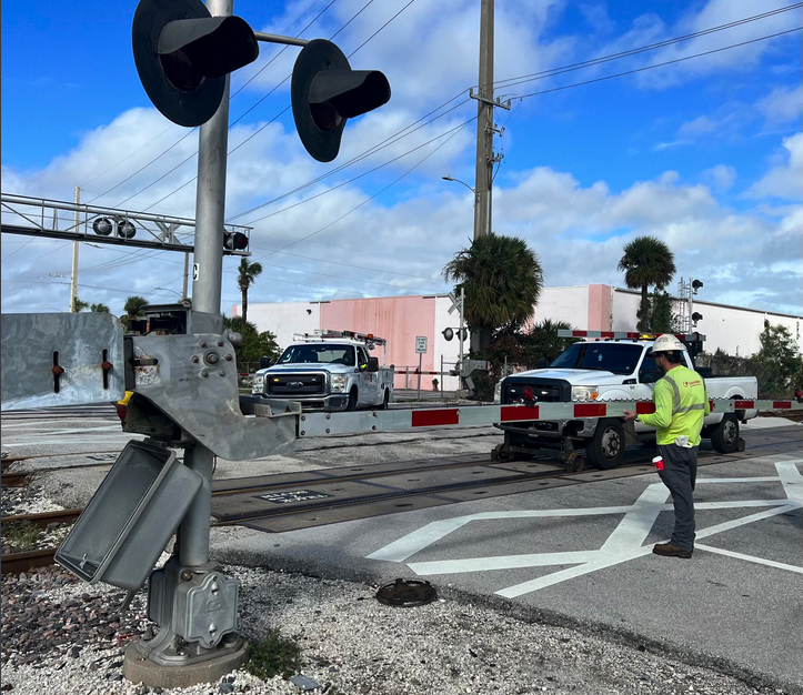 Crew members work at railroad crossing gates