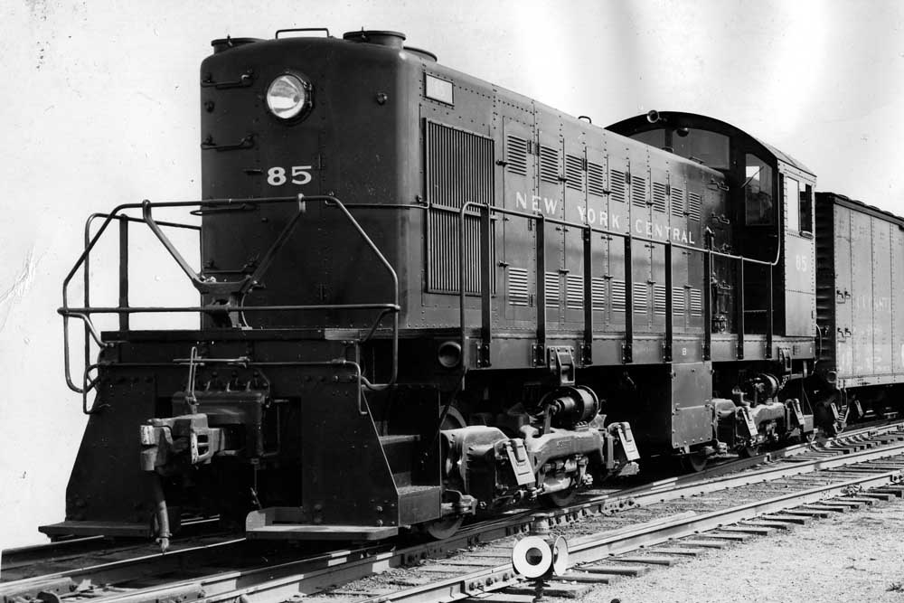 Black end-cab switching locomotive with freight cars