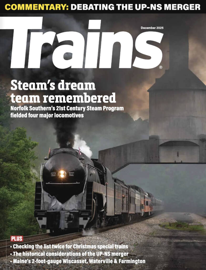 The December 2025 cover of Trains magazine, which features a black steam locomotive advancing towards the camera