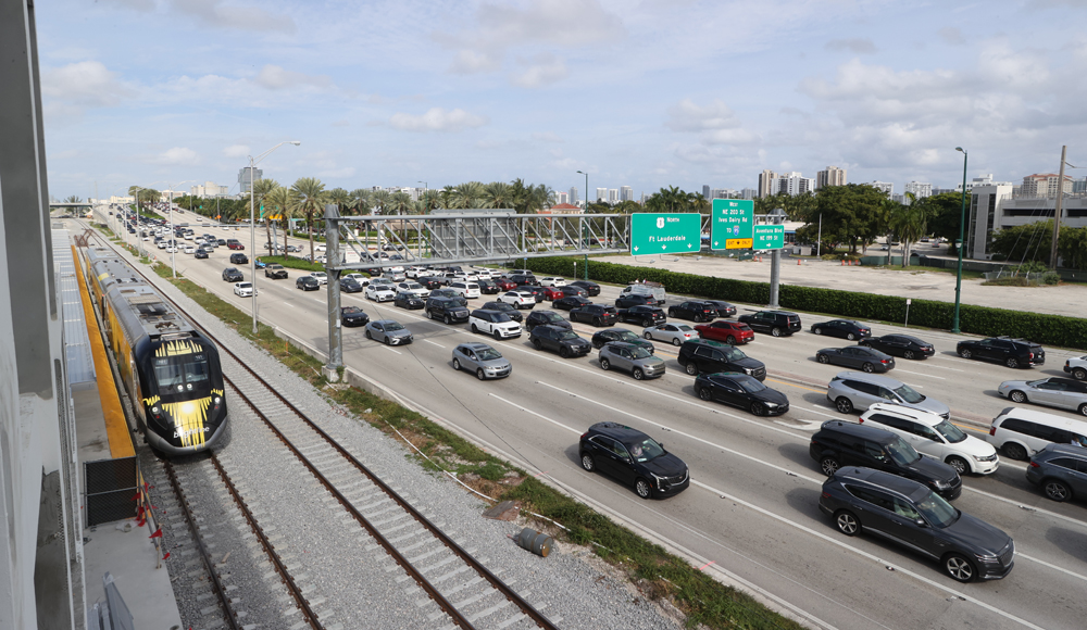 Train stopped at station next to major roadway