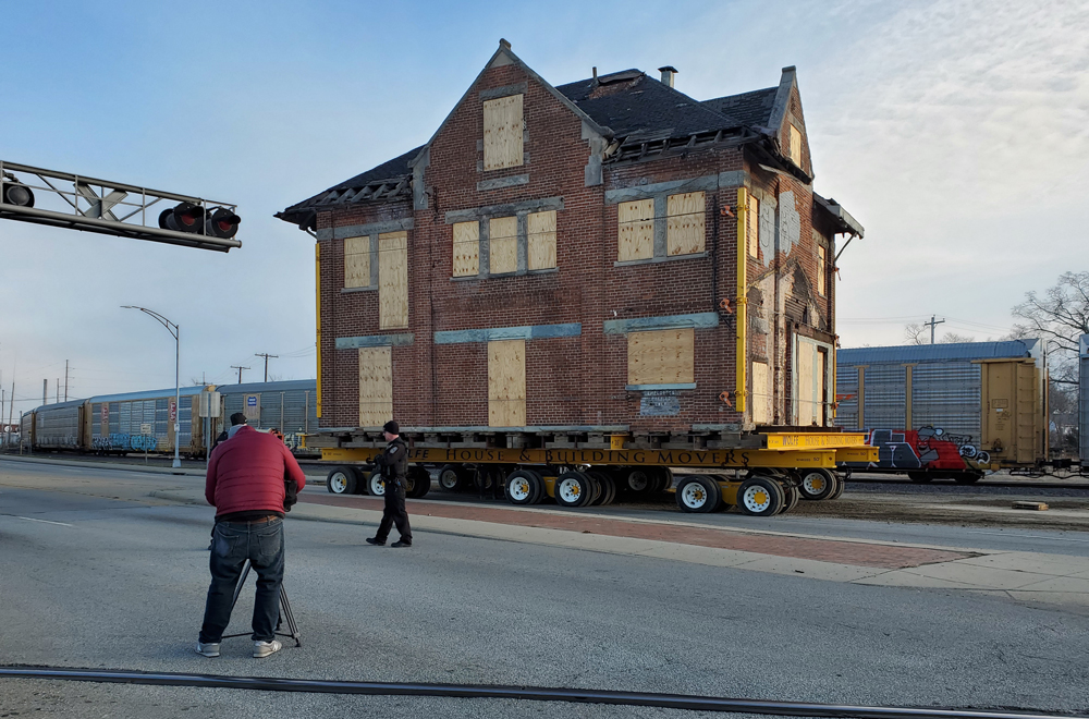 Station building on wheels with train in background