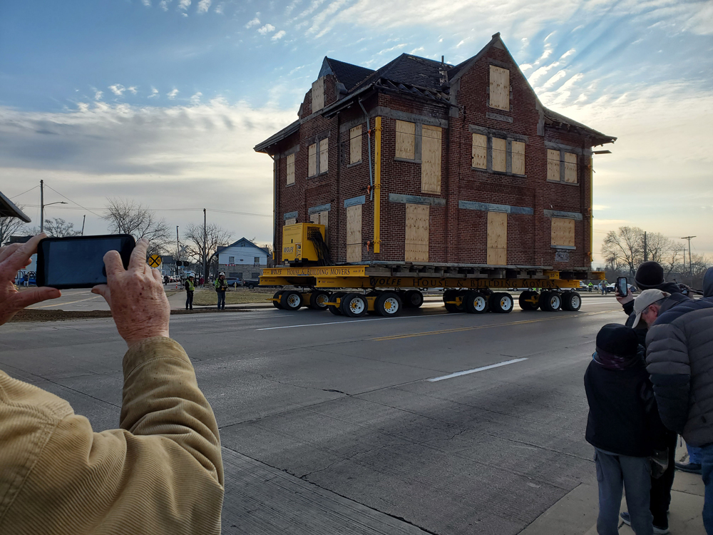 Building on street with people taking pictures in foreground