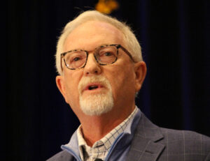 Man with white hair, goatee and glasses