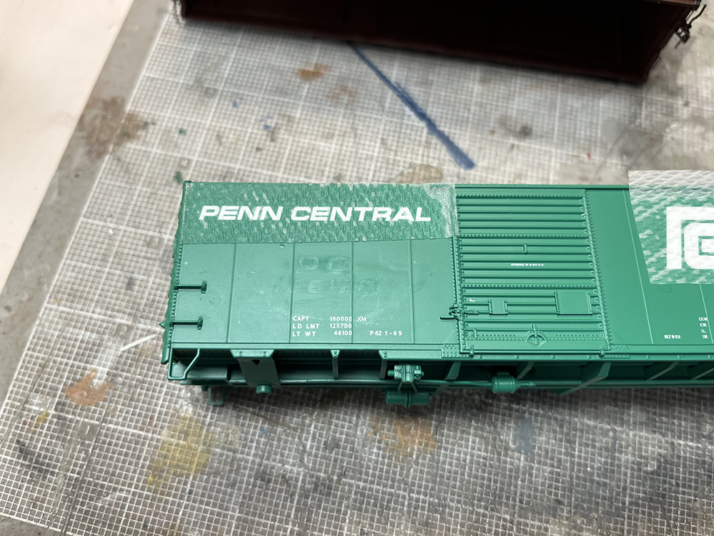Green model boxcar with ghosted white numbers on its side