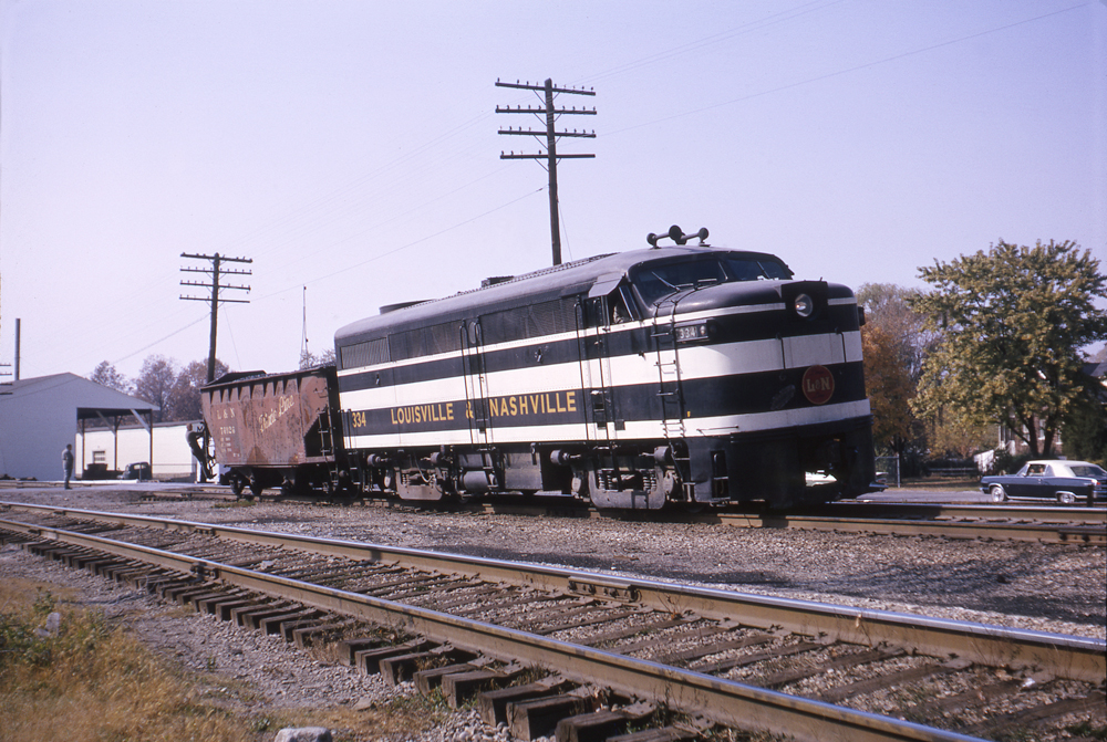 Black-and-white Louisville & Nashville diesel locomotive with hopper freight car