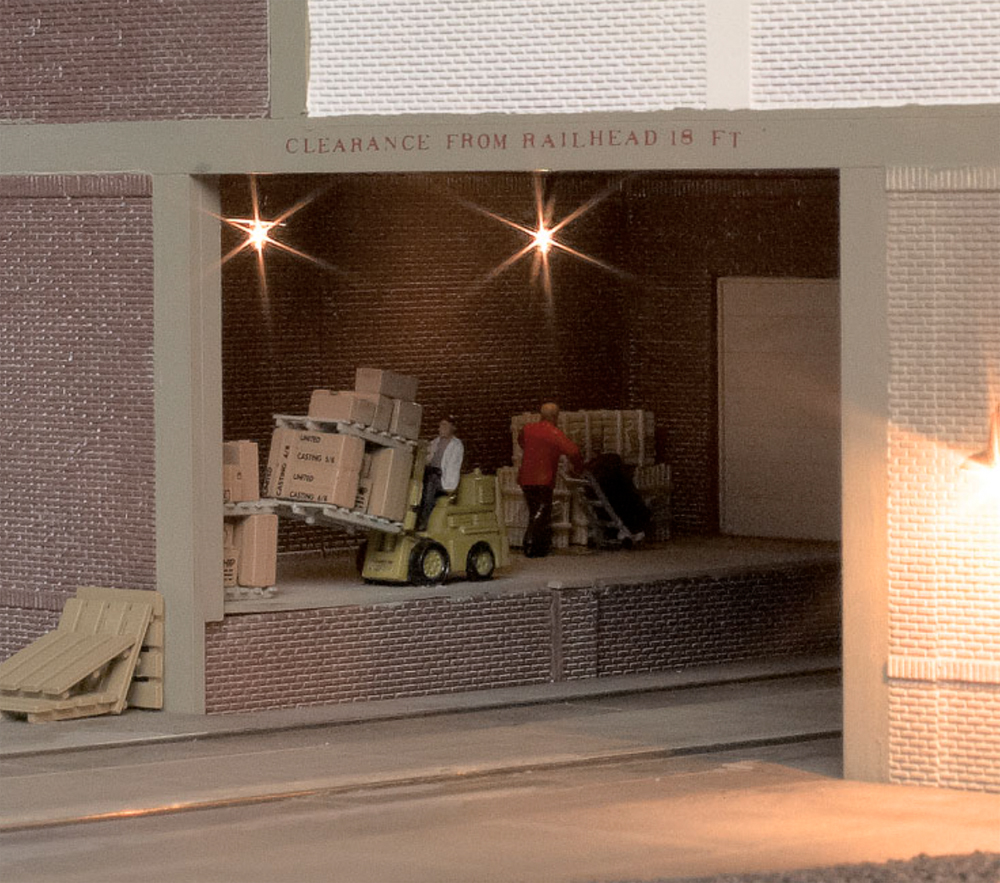 11 easy urban lighting tips for your model railroad layout: An image of workers working in a loading center