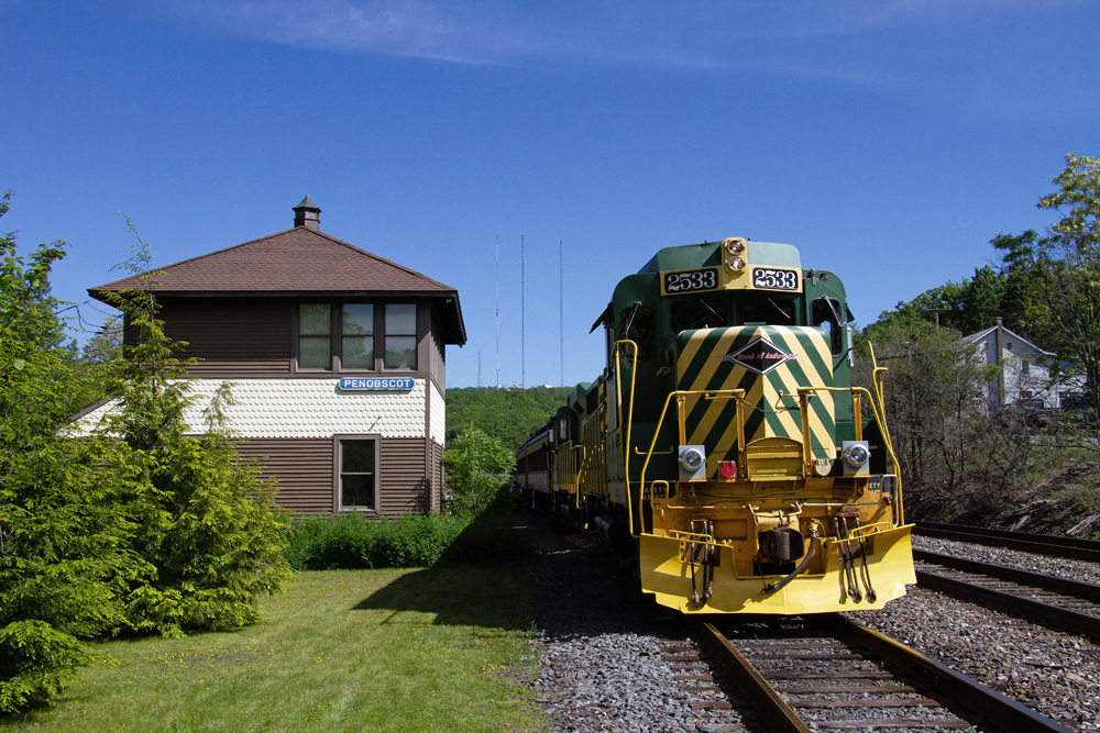Green and yellow diesel next to tower in mountains