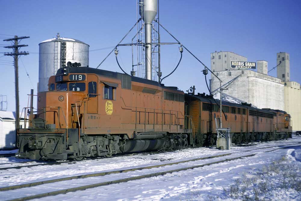 Red-and-black diesel-powered Kansas City Southern locomotives in snow