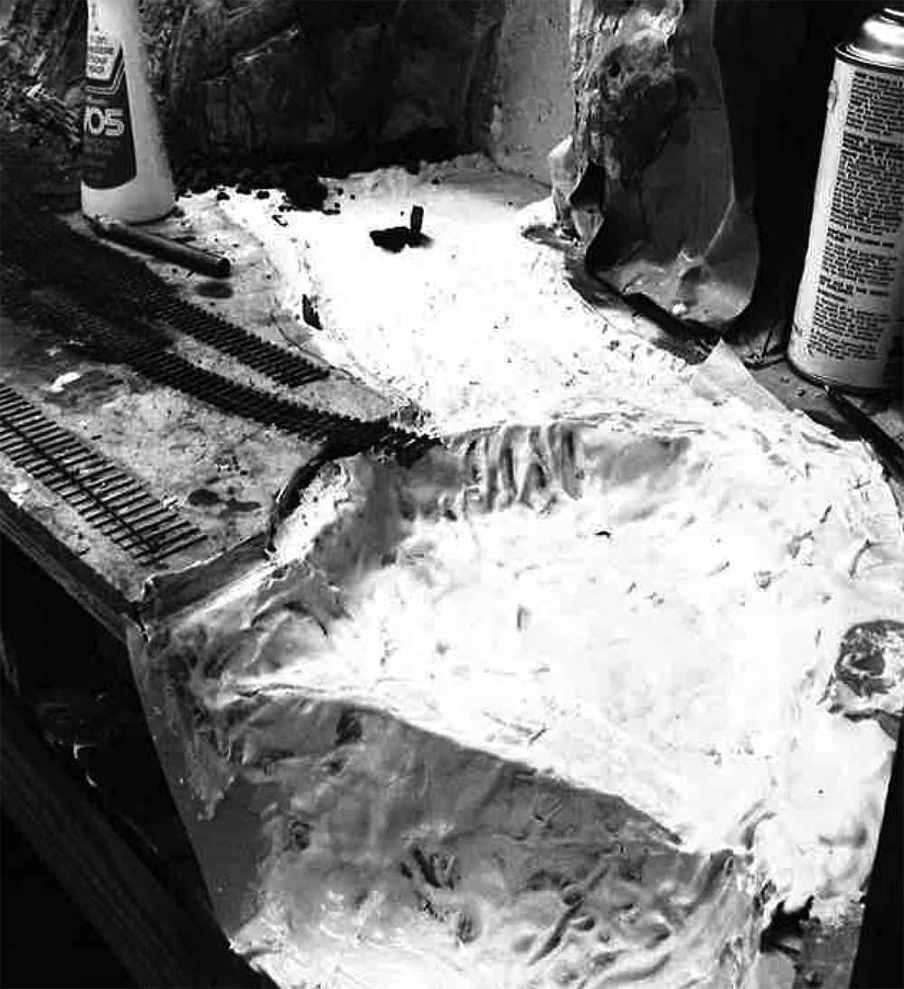 Malcolm Furlow's waterfall modeling technique: Black and white image showing a white plaster-covered riverbed and some of the materials used to make the scene.