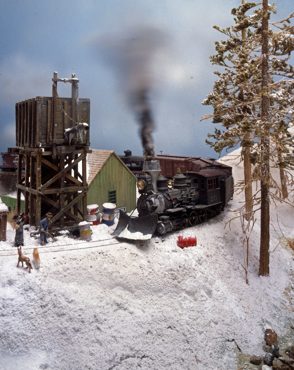 Color photo of steam engine on model railroad.
