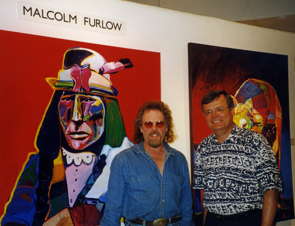 Photo of two men in front of a painting.