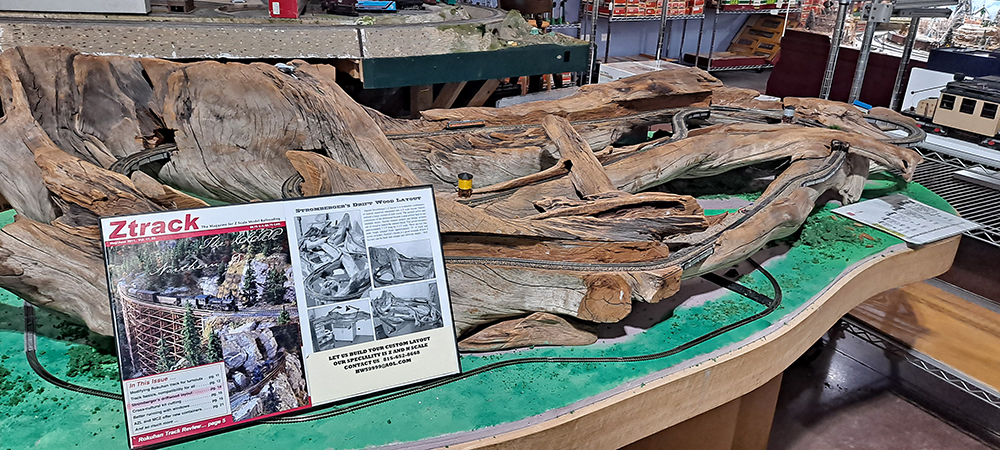 Sculpture made from gray driftwood and small black and silver railroad tracks