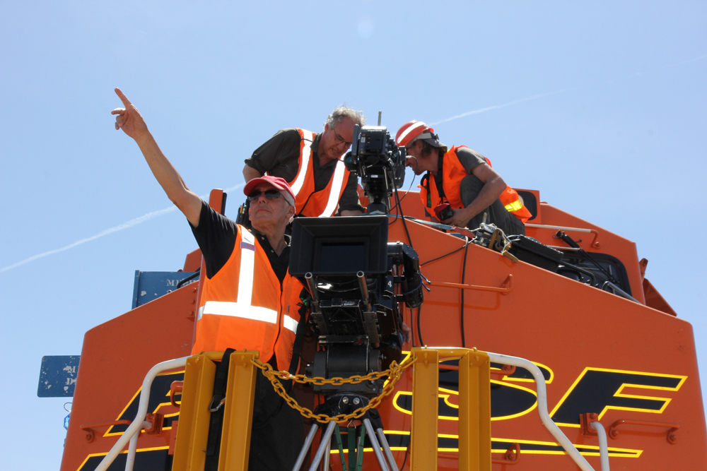 three men shooting film on BNSF diesel