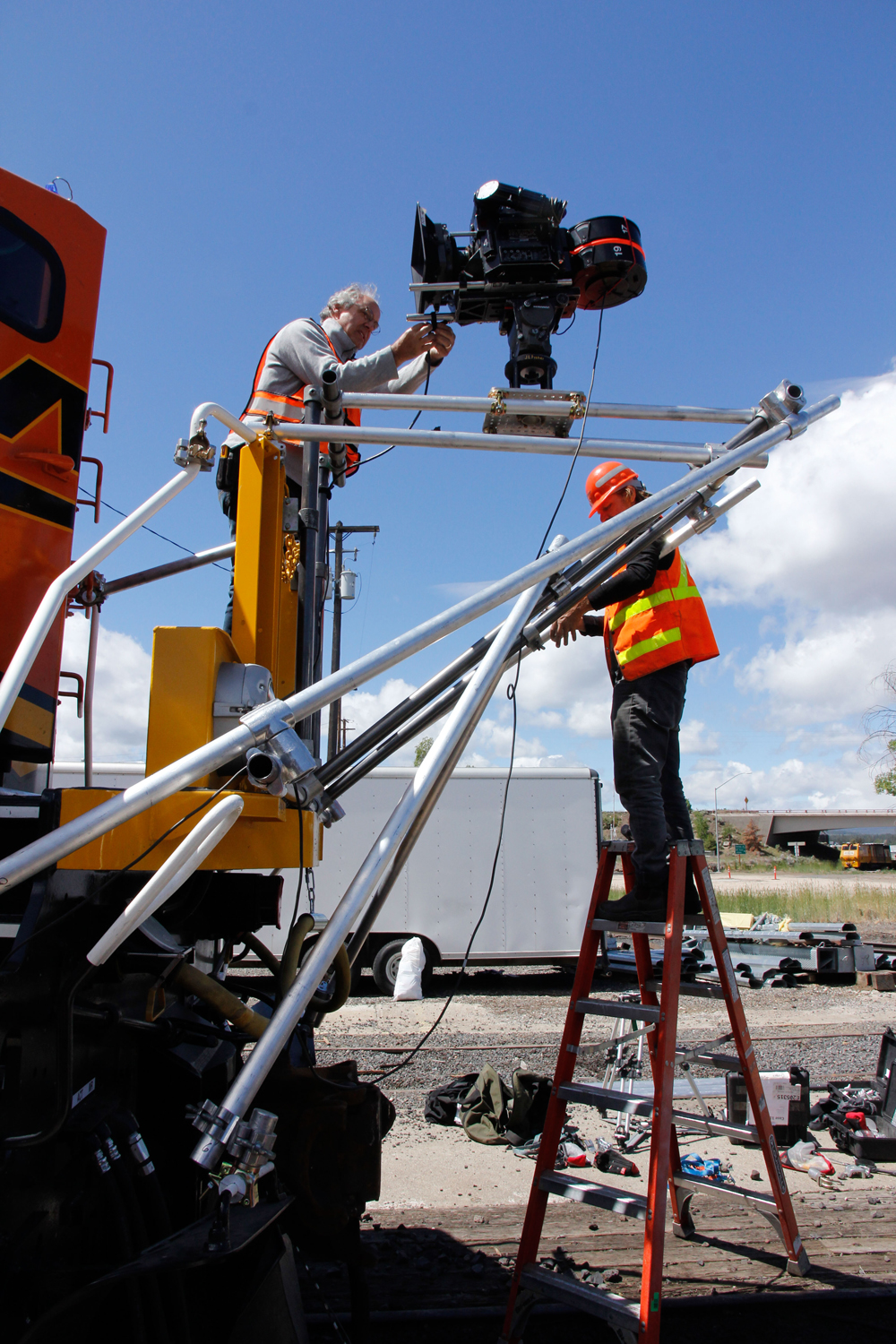 men setting up support system for camera