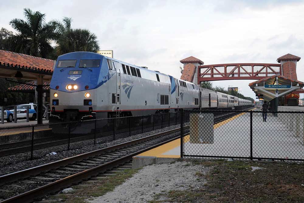 Amtrak Miami services train stopped in station with palm trees