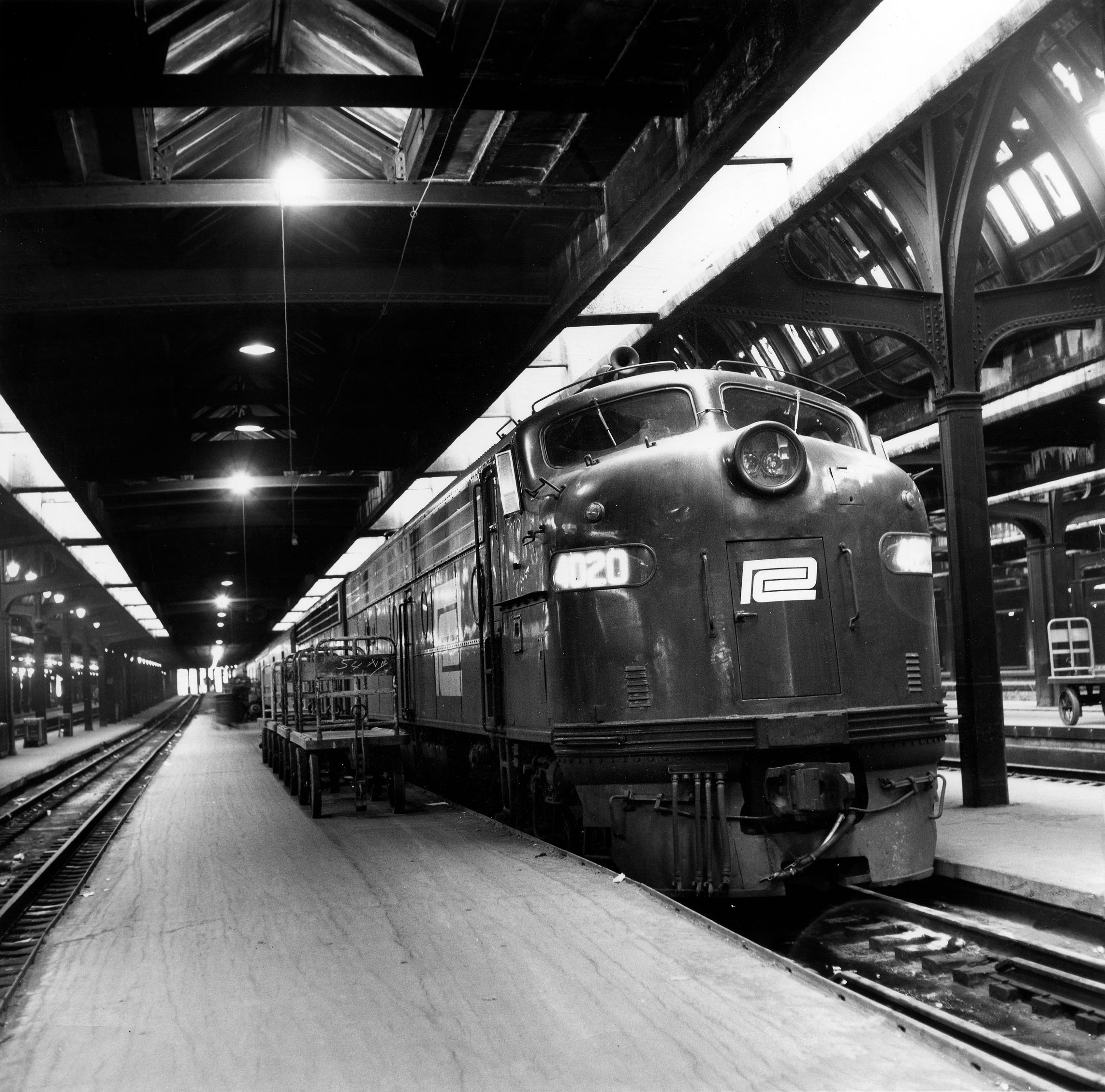 Black-and-white diesel locomotive on covered station platform track