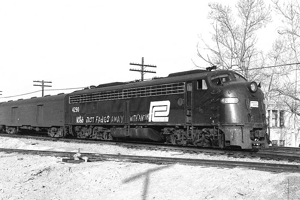 Black-and-white diesel locomotive flying black flags