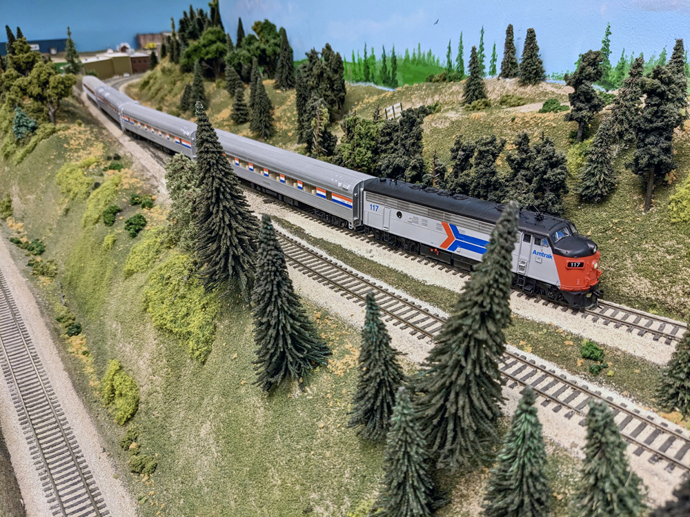 A model passenger train travels through the mountains