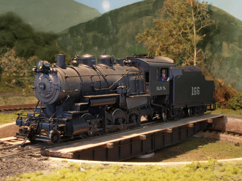 A model steam engine sits on a turntable.