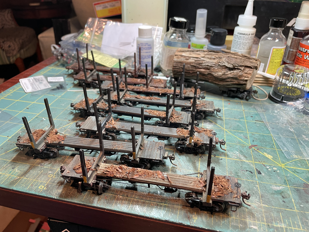 Several skeleton log car models on a workbench