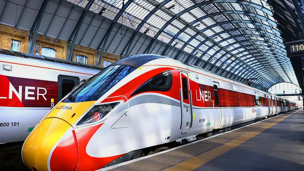 Red, yellow, and white high-speed train standing in station