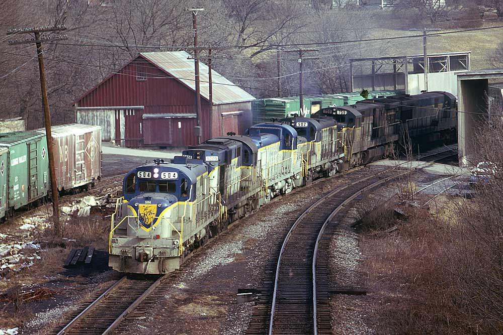 Silver-and-blue diesel Delaware & Hudson locomotives with freight train in town