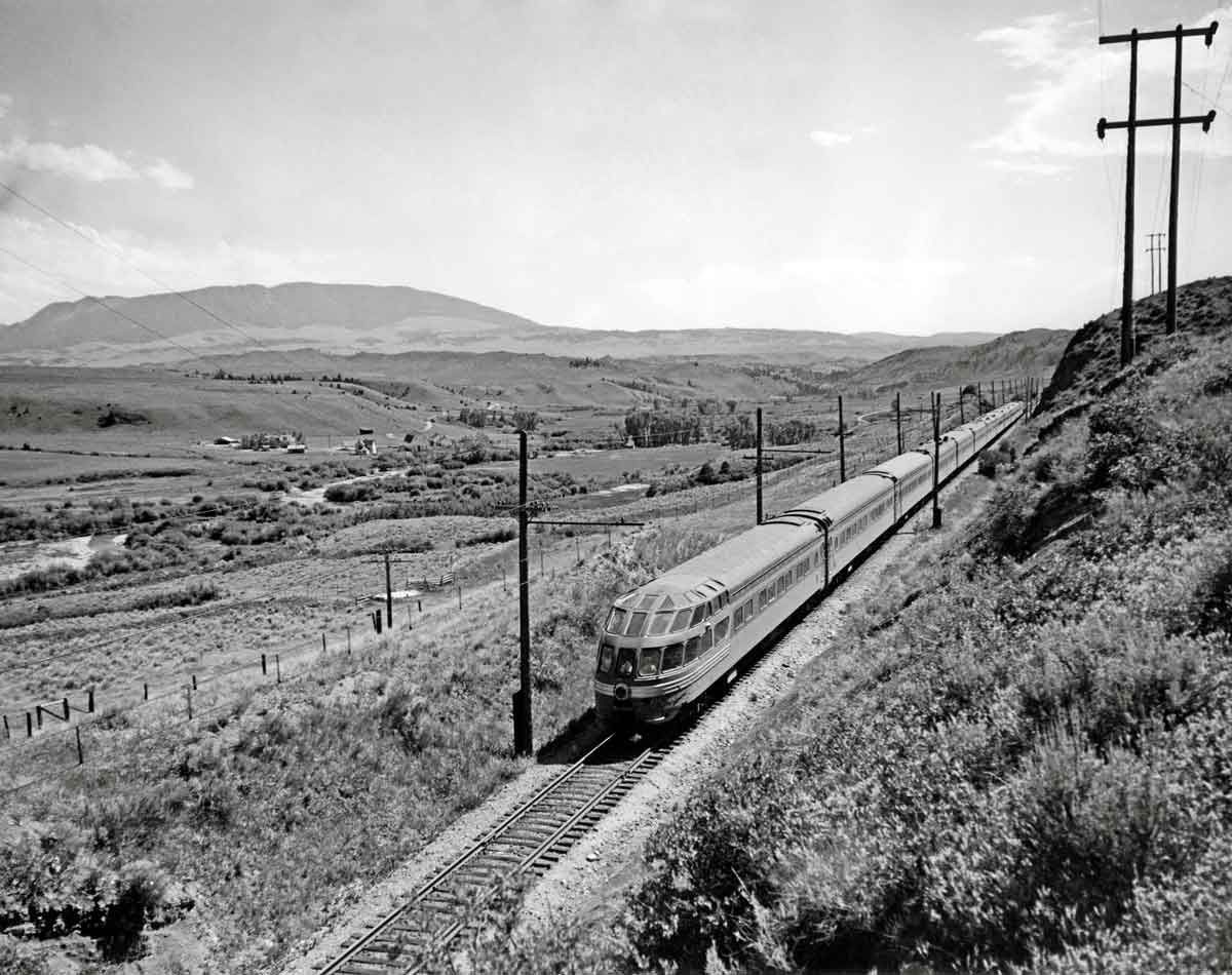 Rear of streamlined passenger train in rolling hills