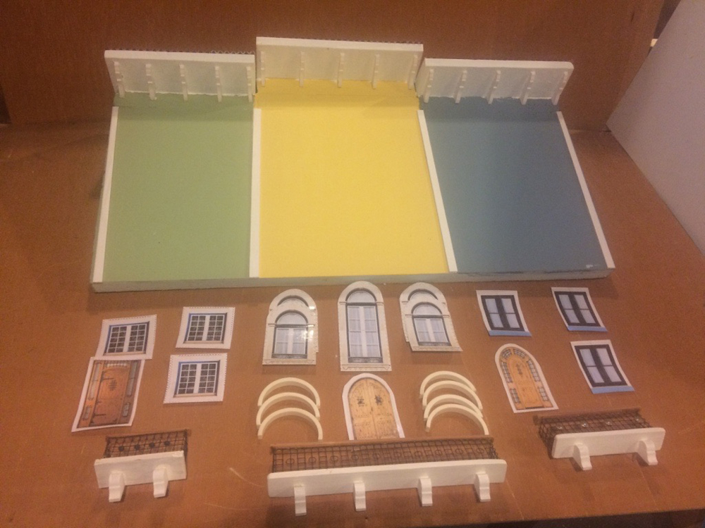 three model buildings with accessories in front of them