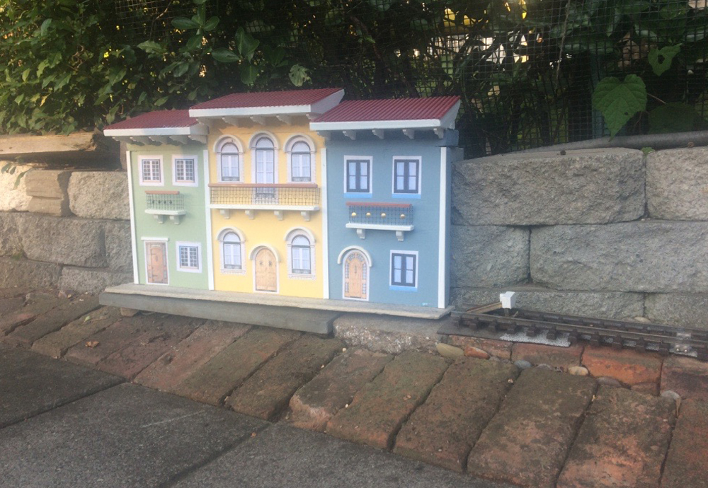 structures installed on garden railway next to fence