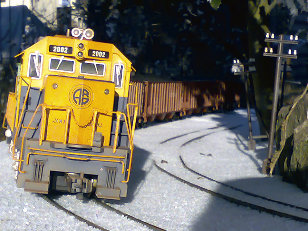 model yellow diesel engine heading toward camera on curve