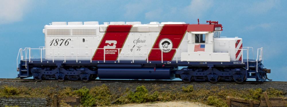 Color image of red, white, and blue HO scale diesel on scenic base.