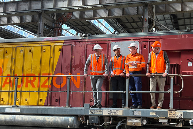 Four men standing on walkway of locomotive