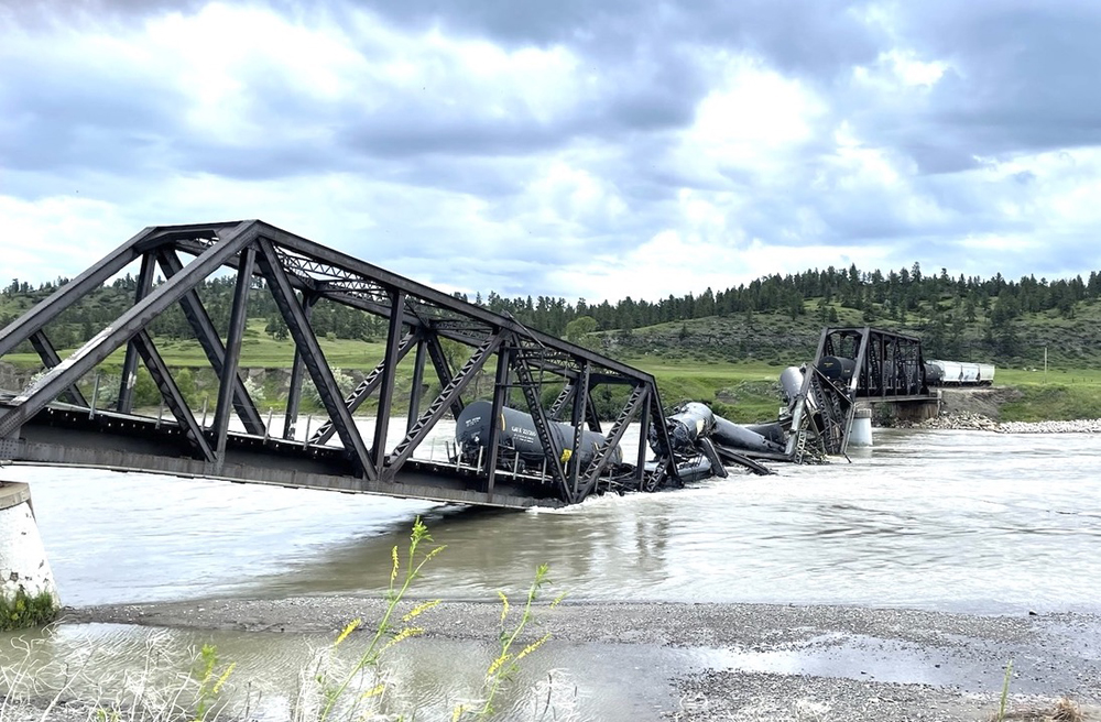 Railroad bridge collapsed into river with railroad cars in water