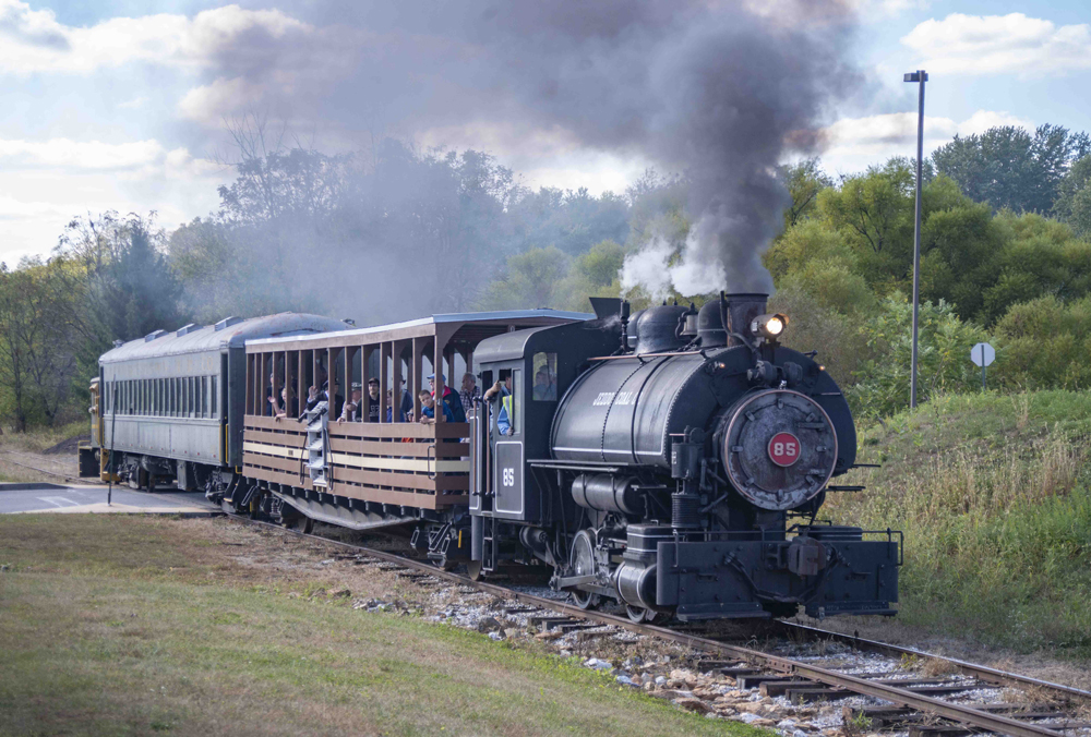 Small tank locomotive pulling two passenger cars