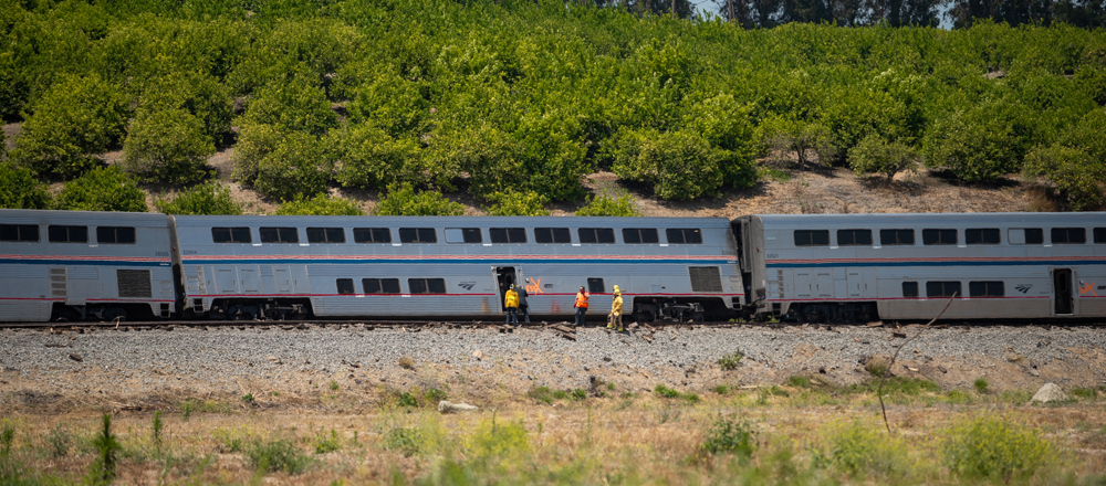 People next to derailed passenger car