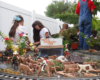 three children in garden railway with cattle figures in front