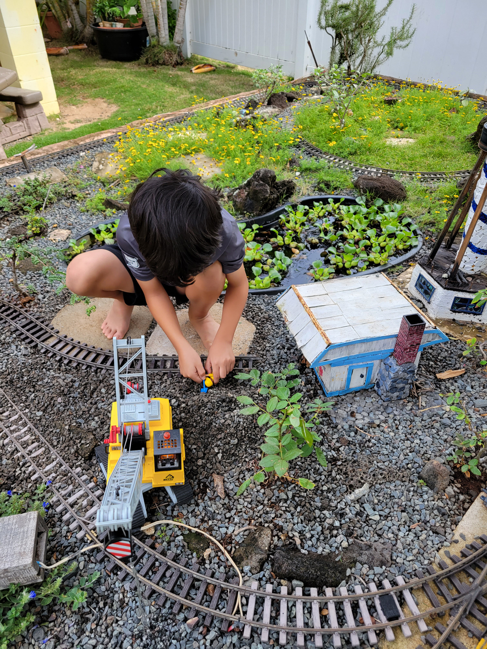 child sitting in garden railway