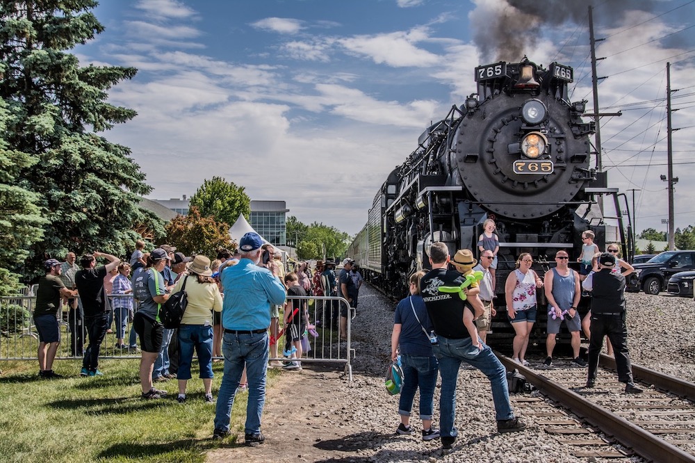 People gather around a steam locomotive during an event. Steam season underway for NKP No. 765 and Indiana Rail Experience.