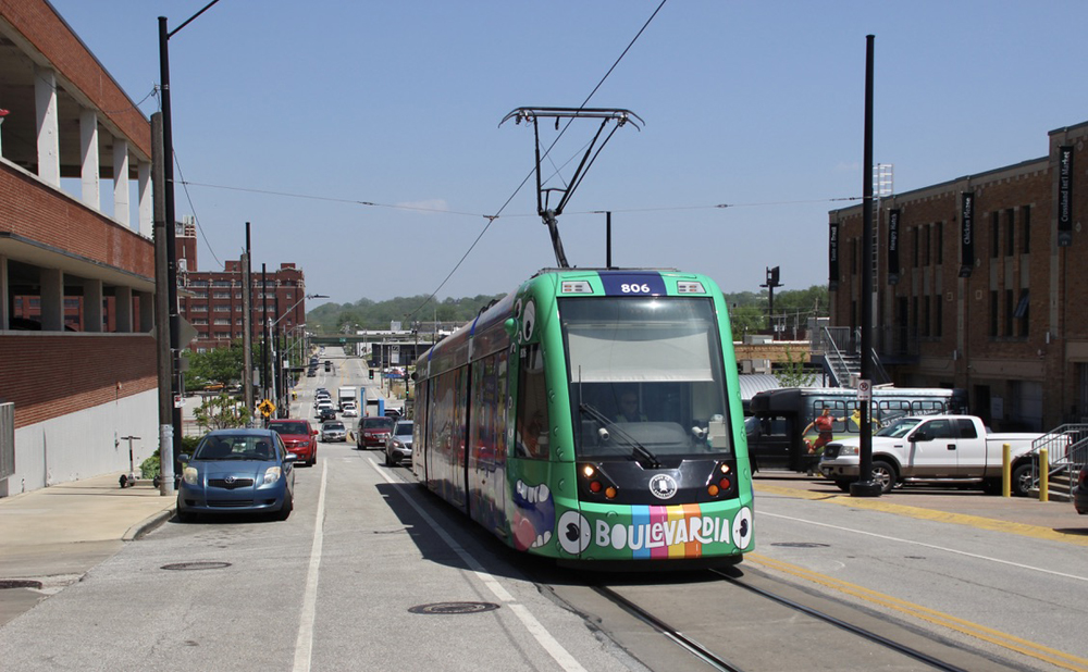 Multicolored light rail vehicle on city street