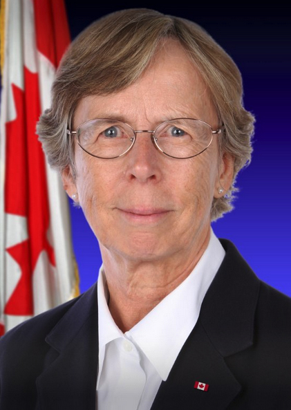 Head shot of woman with Canadian flag in background